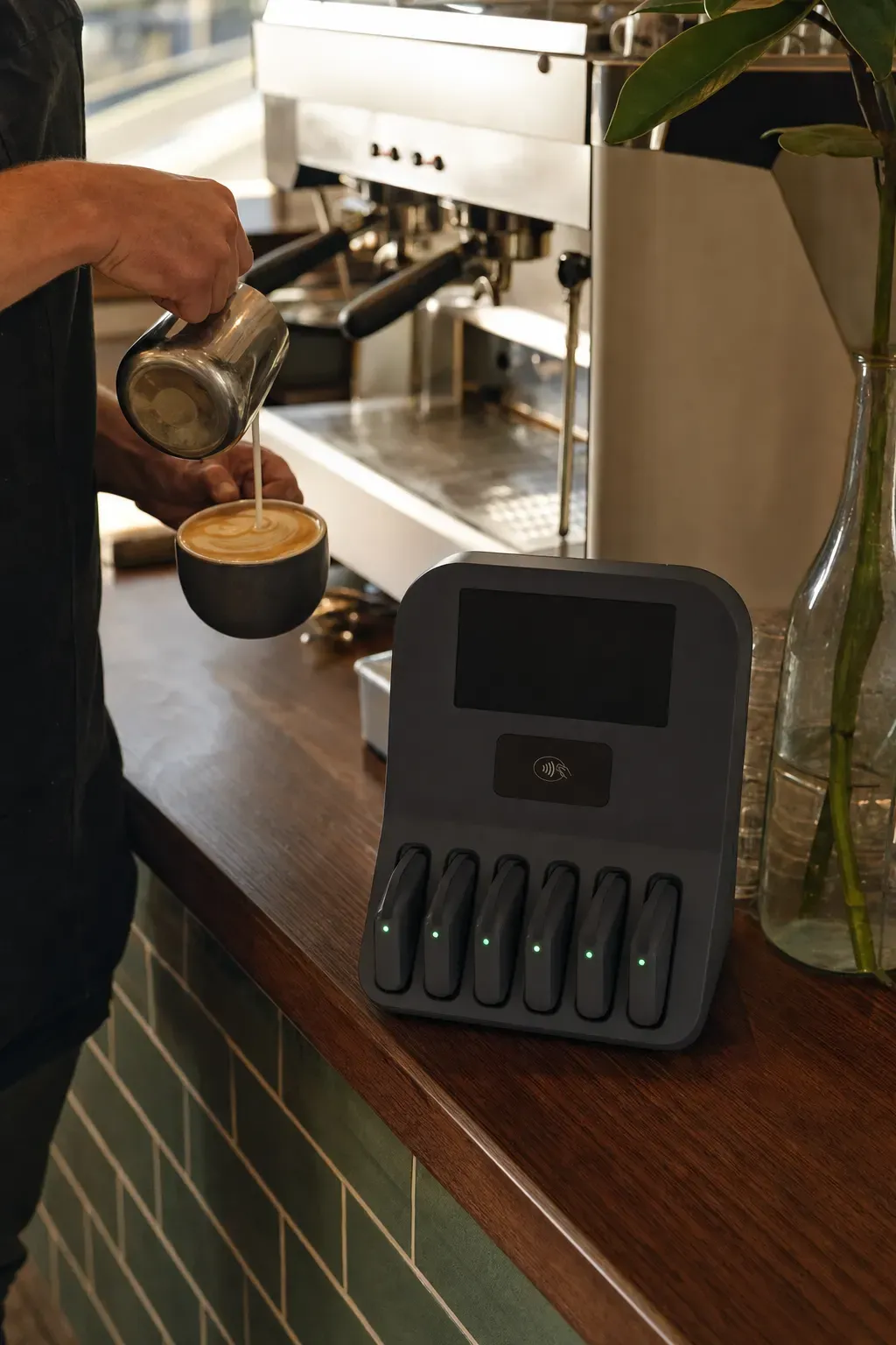 A barista pouring milk, the station at the end of the counter